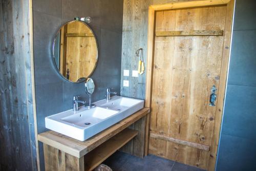 a bathroom with a sink and a mirror and a door at Domaine de Malpas in Villers-le-Lac
