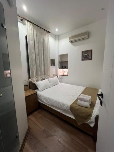 a small bedroom with a bed and a window at Bademli Ancanoz Hotel in Dikili