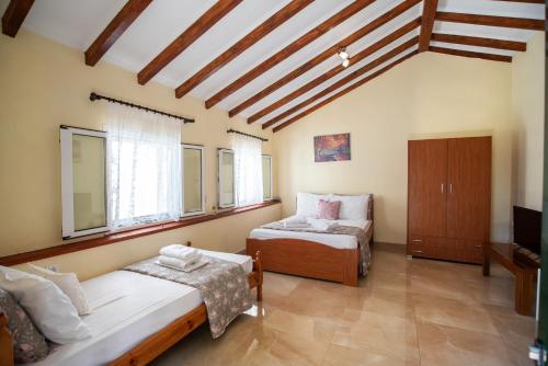 a room with two beds and a chair in it at Potami Studios in Lefkimmi