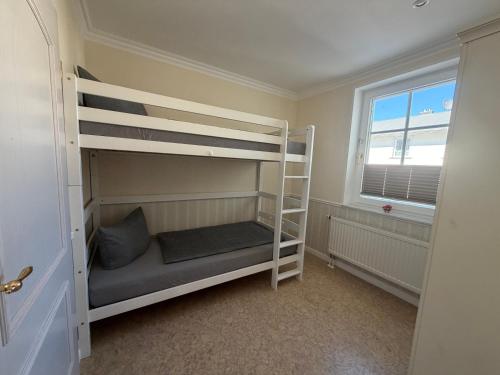 a bedroom with two bunk beds and a window at Appartementhaus, Villa Katharina, Sassnitz in Sassnitz