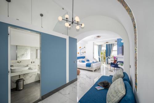 un soggiorno con un divano blu e un bagno di Positano Art Hotel Pasitea a Positano