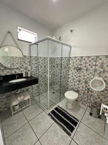 a bathroom with a shower and a toilet and a sink at Aconchego do Lago in Espirito Santo Do Pinhal