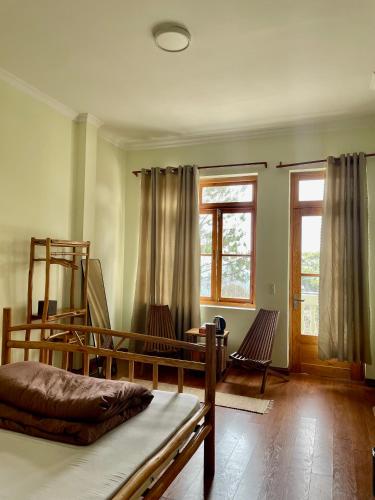 a bedroom with a bed and two chairs and a window at Bếp Thông home in Xuan An