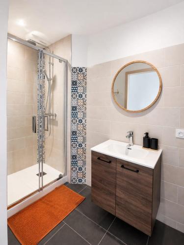 a bathroom with a shower and a sink and a mirror at Studio Les Petits Marcheurs in Saint-Claude