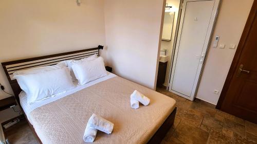 a bedroom with a bed with towels on it at Zen Villa Porto Molo in Ávdhira