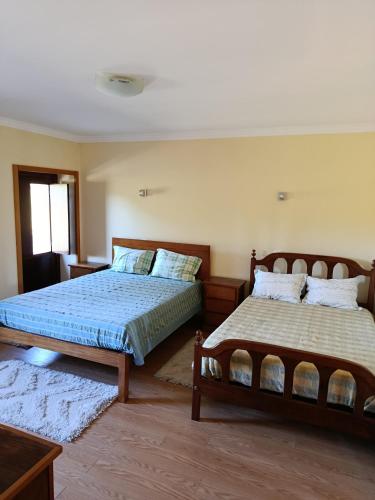 a bedroom with two beds and a window at Casa do Pomarelho in Póvoa de Lanhoso