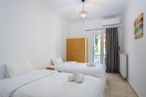 two beds in a room with white walls at Bettys rooms in Paralio Astros