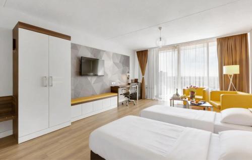 a hotel room with two beds and a tv at MONTAGO Monteur-Apartmenthaus Frankfurt Airport in Neu Isenburg