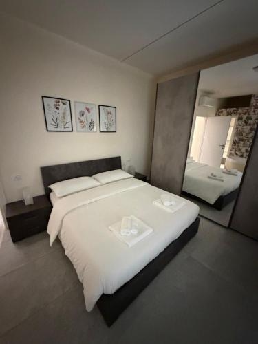 a bedroom with a large white bed and a mirror at Valepiace 1 in Piacenza