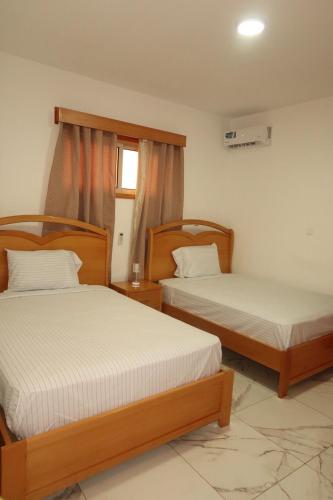 two beds in a room with two beds sidx sidx sidx at Guest House RosAmado in São Filipe