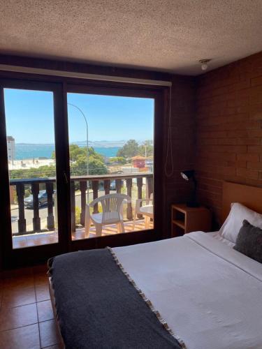 a bedroom with a bed and a view of a balcony at Linda Vista Apart Hotel in Concón