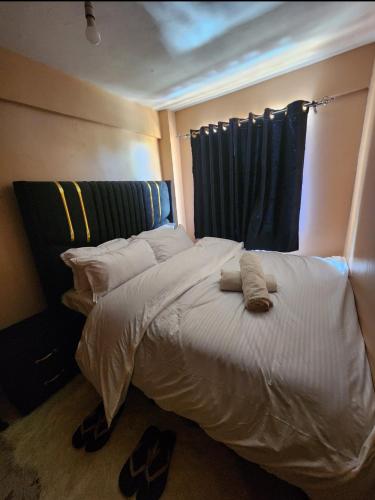 a bedroom with a bed with two towels on it at Pure excellence homes in Ruiru