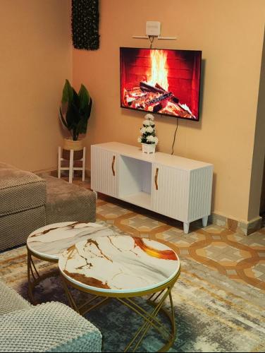 a living room with a fire painting on the wall at Pure excellence homes in Ruiru