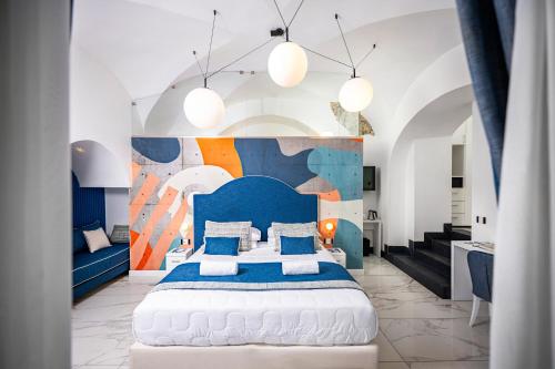 una camera da letto con un grande letto con testiera blu di Positano Art Hotel Pasitea a Positano