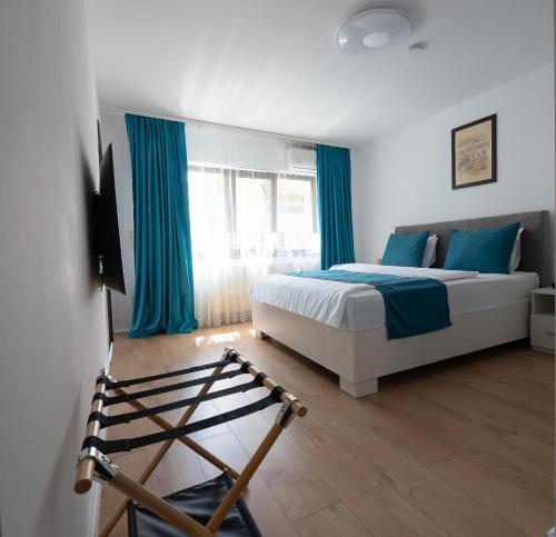 a bedroom with a bed and blue curtains at 3 Baneasa Airport in Bucharest