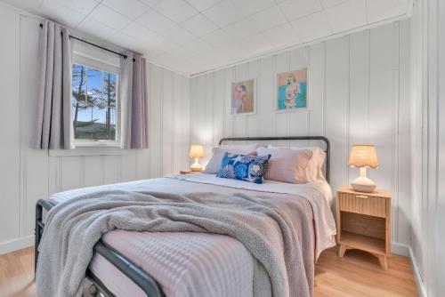 a bedroom with a bed with two lamps and a window at Cornish Cottage Walk to Long Sands Beach in York