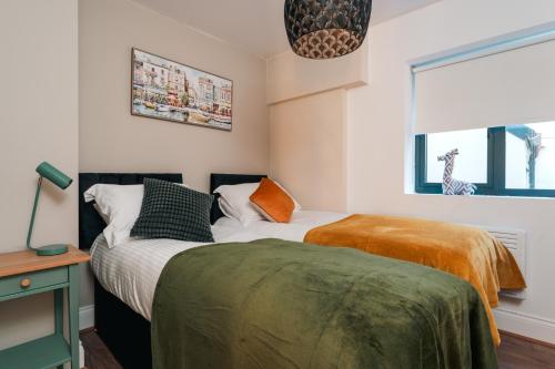 a bedroom with two beds and a window at Stylish Harbourfront Apartment in Torquay