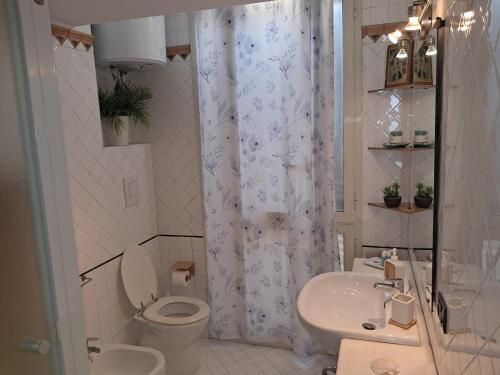 a white bathroom with a toilet and a sink at Terrazza Miracapri in Pozzuoli