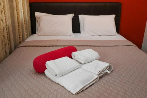 a bed with a red and white blanket and towels at Calm Breeze House in Nea Peramos