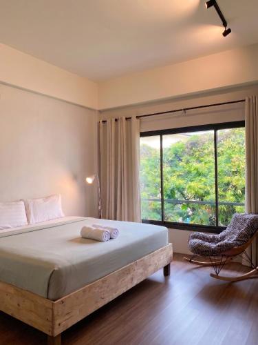 a bedroom with a bed and a large window at CenterPoint Thong Sala in Thong Sala