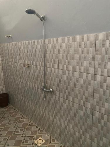 a shower with a shower head in a bathroom at Campement Emanaye in Oussouye