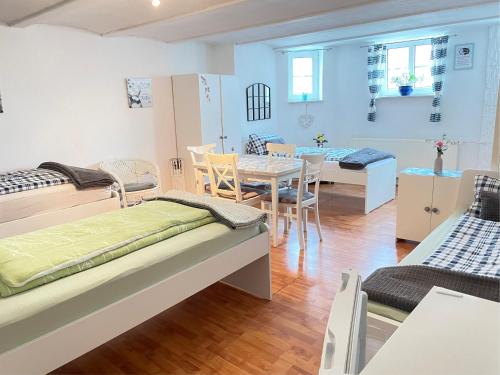a room with two beds and a table and chairs at Pension Nazli Elmshorn in Elmshorn