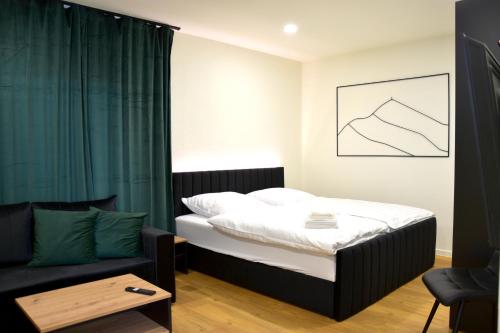 a small bedroom with a bed and a couch at Ferienwohnung Bahnblick - Stilvoll in bester Lage - als Wohnung oder Haus in Olbersdorf