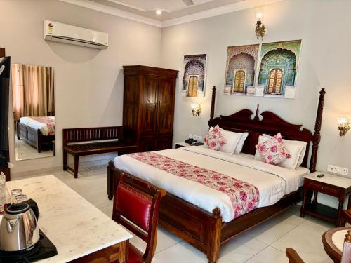 a bedroom with a large bed and a table at Chitawa Haveli A Luxury Heritage Hotel in Jaipur