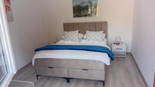 a bedroom with a large bed with a wooden headboard at Apartman Prenj in Konjic