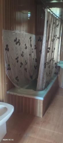 a bath tub with a shower curtain in a bathroom at House boat MASHAL in Srinagar