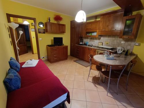 a room with a bed and a table and a kitchen at Casa Del Cuore in Torre Pellice