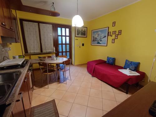 a living room with a red couch and a table at Casa Del Cuore in Torre Pellice