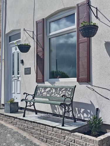 a bench sitting in front of a window at Copper Mine Cottage in Llandudno