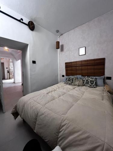 a bedroom with a large bed with a wooden headboard at دارالقوس in Sfax