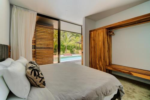 a bedroom with a bed and a large window at Private Jungle House No1Calalu with AC, Pool & EV in Talamanca
