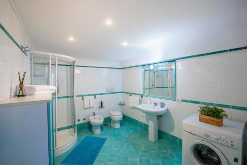 a bathroom with two toilets and a sink and a washing machine at Casa Marina in Praiano