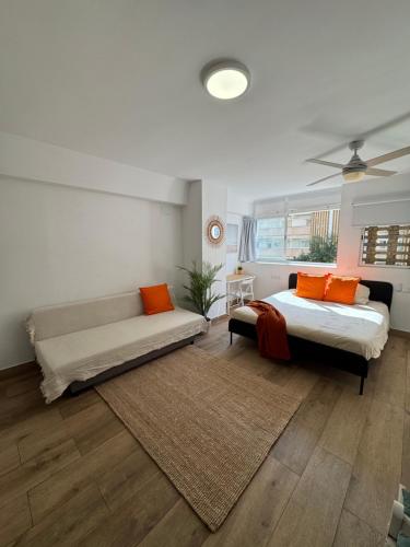 a bedroom with a bed and a couch at Ideal parejas Estudio Granadella en Jávea in Platja de l'Arenal