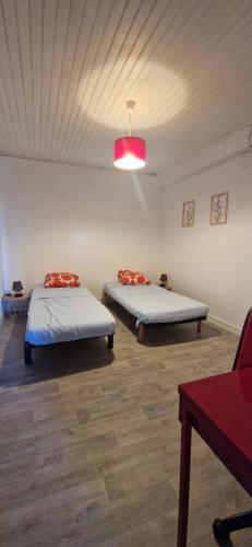 a room with two beds and a pink light at Appartement St montan in Saint-Montan