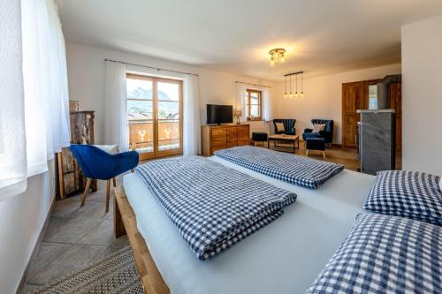 a bedroom with two beds and a living room at Haus Lara - Fewo 2 in Wallgau