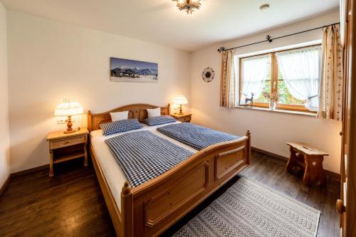a bedroom with a wooden bed and a window at Haus Lara - Fewo 1 in Wallgau