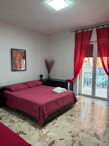 a bedroom with a large red bed with red curtains at Dayana House in Gallipoli