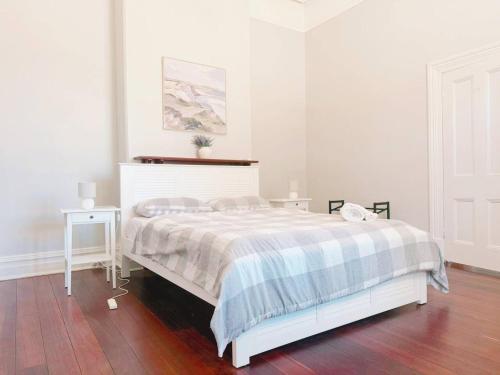 a white bedroom with a bed and a table at Full house - Heritage Charm Meets Modern Ease in Midland Junction