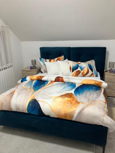 a bedroom with a blue bed with a painting on it at Sobe VaLux Valpovo in Valpovo
