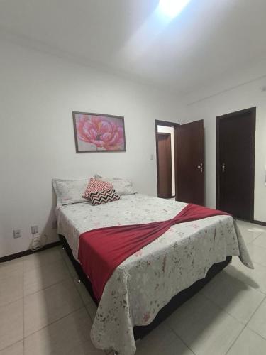 a bedroom with a large bed with a red blanket at Morada Vermelha in Vitória da Conquista