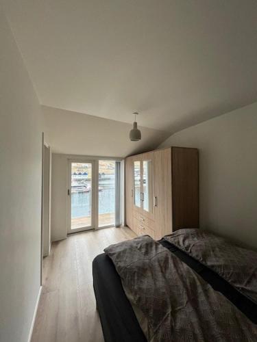 a bedroom with a bed and a large window at The Red Boat House in Vestmanna