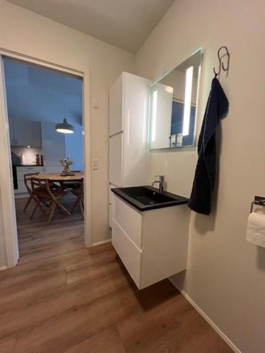 a kitchen with a sink and a mirror and a table at The Red Boat House in Vestmanna
