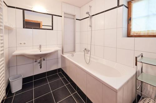 a white bathroom with a sink and a bath tub at Haus Traudl in Filzmoos