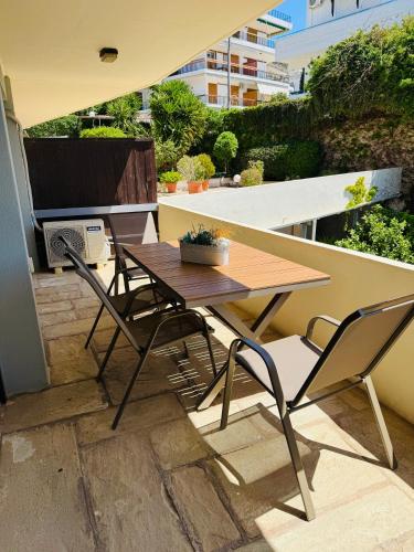 a wooden table and chairs on a balcony at Sophia's apartment in Saronida