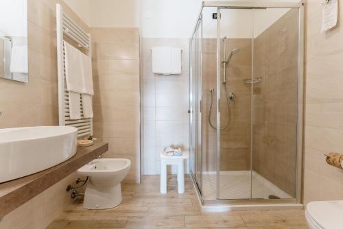 a bathroom with a shower and a toilet and a sink at Hotel Eden Salò in Salò