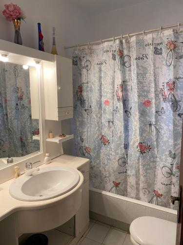 a bathroom with a sink and a shower curtain at Aiolos in Skala